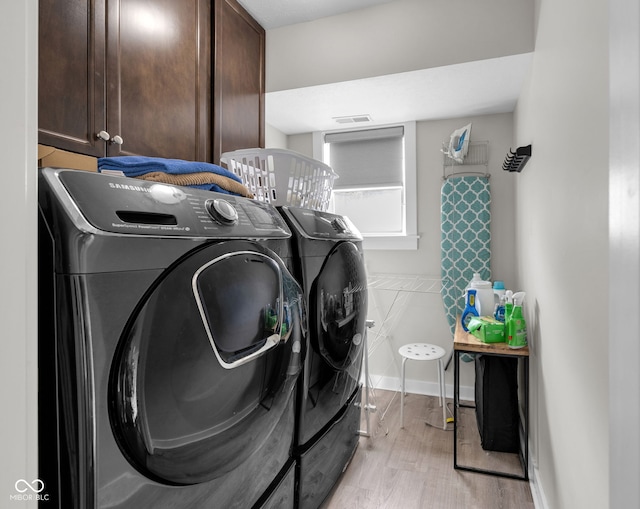 3101 N Washington Blvd, Indianapolis, IN 46205 - laundry area with cabinet space, washing machine and clothes dryer, and light wood-style flooring