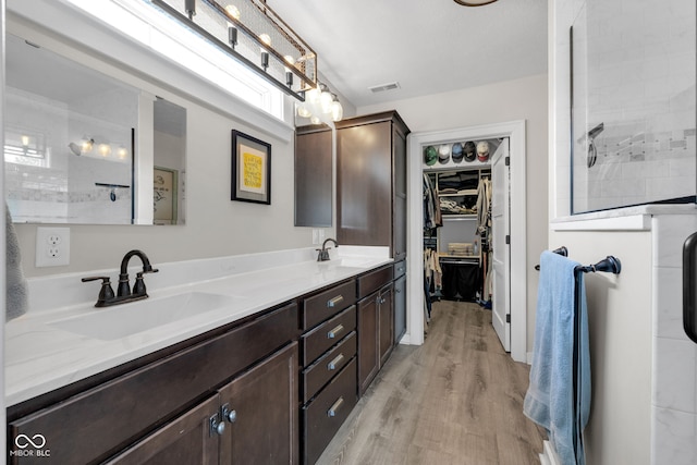 3101 N Washington Blvd, Indianapolis, IN 46205 - bathroom with double vanity, wood finished floors, a walk in closet, and a tile shower