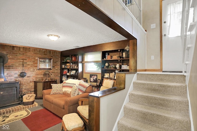 2777 S 600 E, Franklin, IN 46131 - living area featuring a wood stove, a textured ceiling, stairway, and brick wall