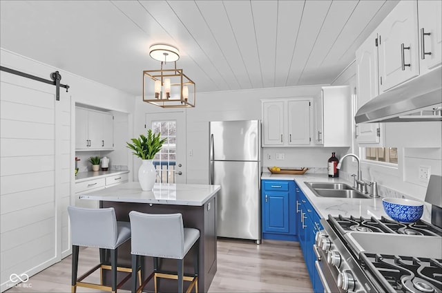 2829 Dakota Dr, Anderson, IN 46012 - kitchen featuring stainless steel appliances, blue cabinets, under cabinet range hood, white cabinets, and a kitchen island
