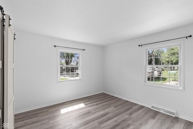 2829 Dakota Dr, Anderson, IN 46012 - spare room featuring a barn door and light wood-style floors