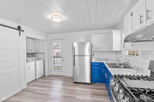 2829 Dakota Dr, Anderson, IN 46012 - kitchen featuring stainless steel appliances, washing machine and clothes dryer, blue cabinetry, under cabinet range hood, and white cabinetry