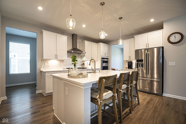 14404 Stairbridge Pl, Carmel, IN 46074 - kitchen with stainless steel appliances, wall chimney range hood, decorative backsplash, an island with sink, and light countertops