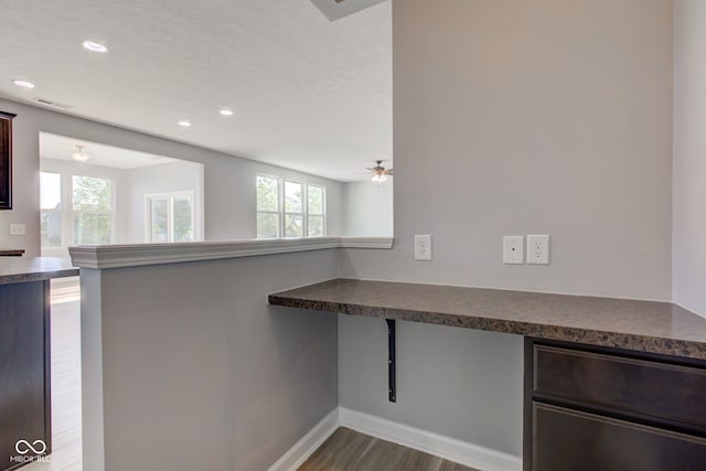 14620 Hinton Dr, Fishers, IN 46037 - kitchen with dark countertops, dark wood-style floors, recessed lighting, dark brown cabinets, and a peninsula