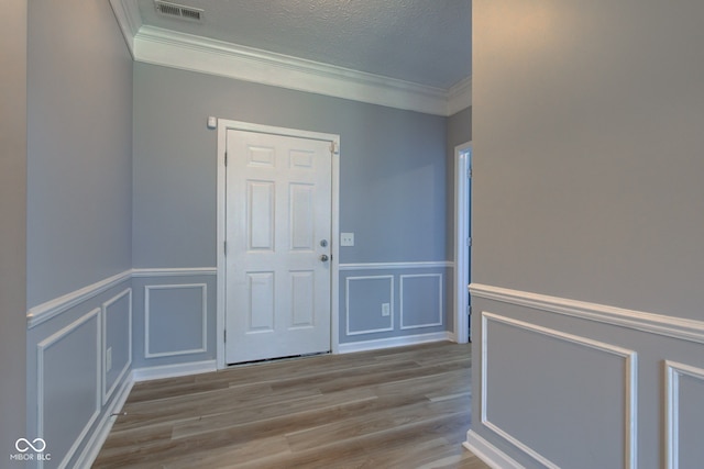 14620 Hinton Dr, Fishers, IN 46037 - foyer entrance with ornamental molding, wood finished floors, a decorative wall, and a wainscoted wall