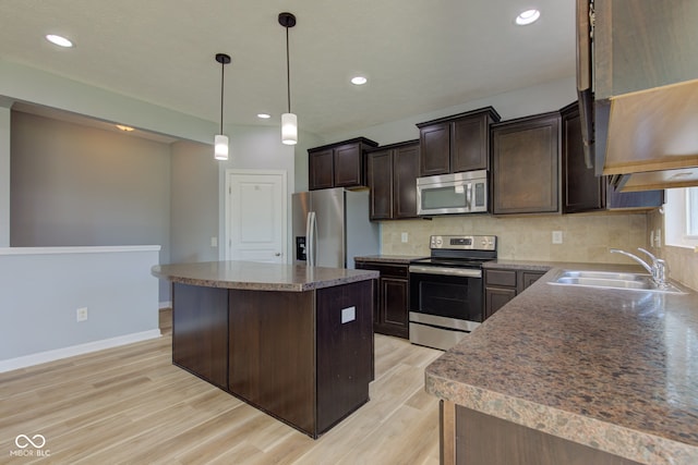 14620 Hinton Dr, Fishers, IN 46037 - kitchen with appliances with stainless steel finishes, light wood-style flooring, dark brown cabinets, a center island, and decorative backsplash