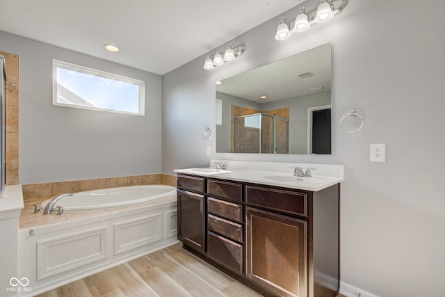 14620 Hinton Dr, Fishers, IN 46037 - bathroom featuring a garden tub, a stall shower, double vanity, and wood finished floors