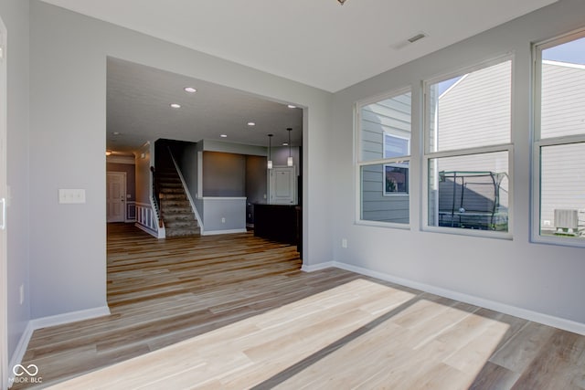 14620 Hinton Dr, Fishers, IN 46037 - spare room featuring stairway, light wood-style flooring, healthy amount of natural light, and recessed lighting