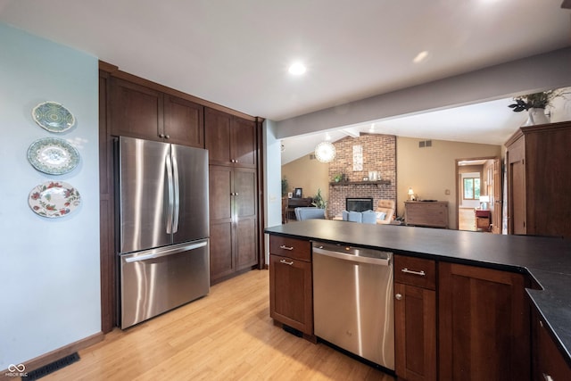 3711 Tara Ct, Carmel, IN 46074 - kitchen with appliances with stainless steel finishes, dark countertops, lofted ceiling, light wood-type flooring, and a peninsula