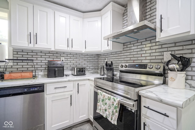 5902 Oak Ln, Anderson, IN 46013 - kitchen featuring appliances with stainless steel finishes, wall chimney range hood, backsplash, and white cabinets