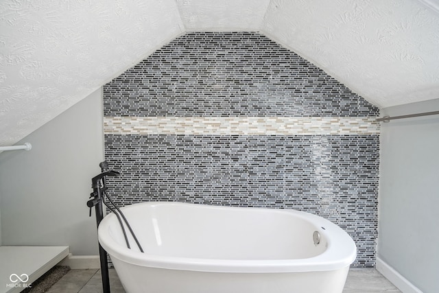 5902 Oak Ln, Anderson, IN 46013 - full bath featuring a textured ceiling, lofted ceiling, and a freestanding bath