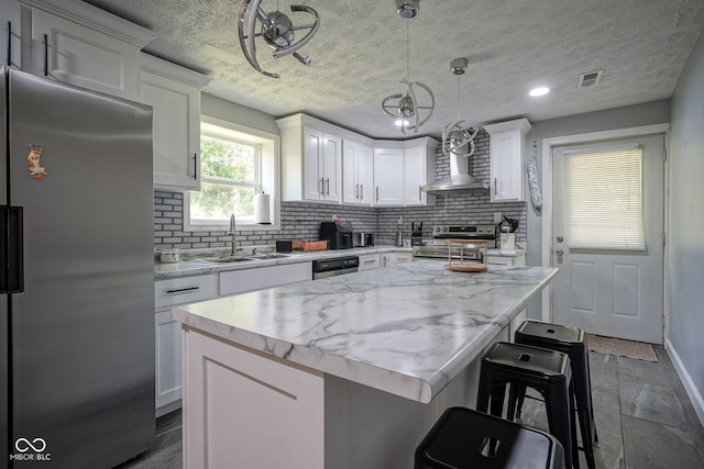 5902 Oak Ln, Anderson, IN 46013 - kitchen with appliances with stainless steel finishes, wall chimney range hood, backsplash, white cabinetry, and recessed lighting