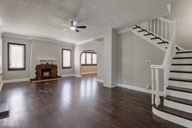 4155 Graceland Ave, Indianapolis, IN 46208 - unfurnished living room featuring a ceiling fan, stairs, a textured ceiling, dark wood-type flooring, and arched walkways