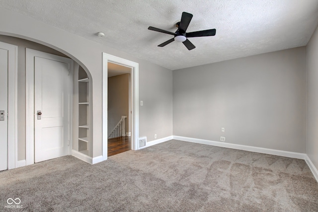 4155 Graceland Ave, Indianapolis, IN 46208 - unfurnished bedroom with carpet floors, a textured ceiling, arched walkways, and ceiling fan