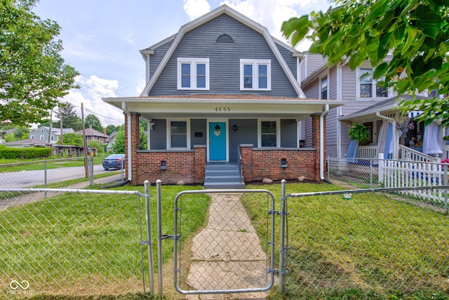 4155 Graceland Ave, Indianapolis, IN 46208 - colonial inspired home with a gate, a gambrel roof, a porch, brick siding, and a fenced front yard