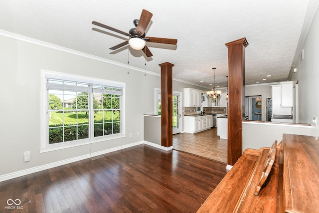 3050 Montgomery Blvd, Lapel, IN 46051 - unfurnished living room featuring a chandelier, a ceiling fan, dark wood-style flooring, decorative columns, and ornamental molding