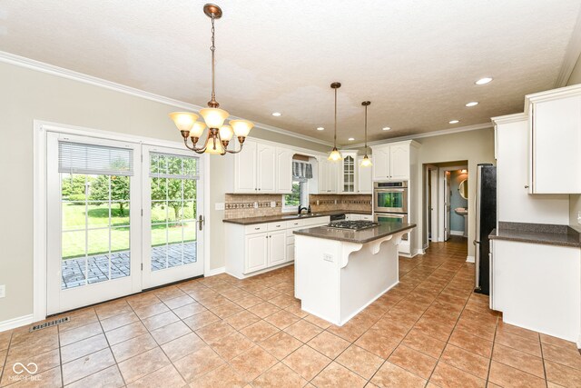 3050 Montgomery Blvd, Lapel, IN 46051 - kitchen with dark countertops, appliances with stainless steel finishes, a center island, decorative backsplash, and white cabinets