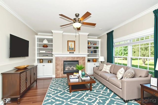 3050 Montgomery Blvd, Lapel, IN 46051 - living area with crown molding, ceiling fan, wood finished floors, a tile fireplace, and built in shelves