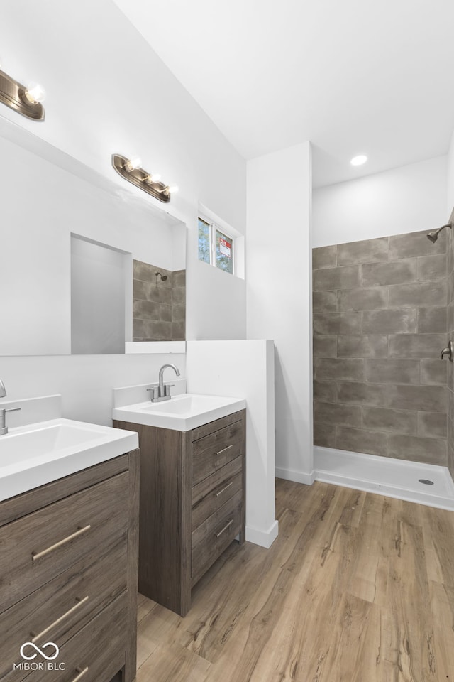 2709 Station St, Indianapolis, IN 46218 - bathroom with two vanities, tiled shower, and wood finished floors