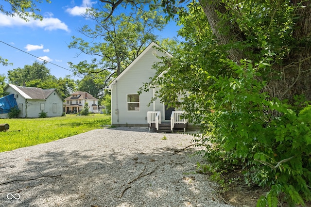 2709 Station St, Indianapolis, IN 46218 - back of house featuring a yard, gravel driveway, and a wooden deck