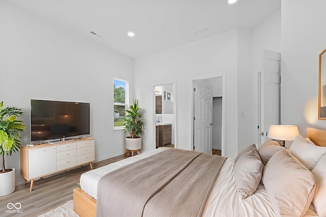 2709 Station St, Indianapolis, IN 46218 - bedroom with light wood finished floors, recessed lighting, ensuite bathroom, and a walk in closet