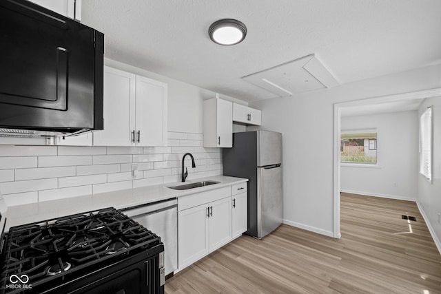 1730 S State Ave, Indianapolis, IN 46203 - kitchen with black gas range, freestanding refrigerator, dishwasher, light countertops, and light wood-type flooring
