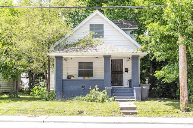 2650 S Meridian St, Indianapolis, IN 46225 - view of front of house featuring brick siding, covered porch, a front lawn, and a shingled roof