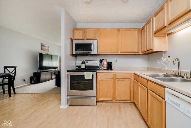 4020 Eisenhower Dr, Indianapolis, IN 46254 - kitchen featuring stainless steel appliances, light wood-style floors, light countertops, a textured ceiling, and light brown cabinets
