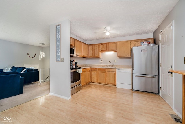 4020 Eisenhower Dr, Indianapolis, IN 46254 - kitchen with appliances with stainless steel finishes, light wood finished floors, ceiling fan, light countertops, and open floor plan