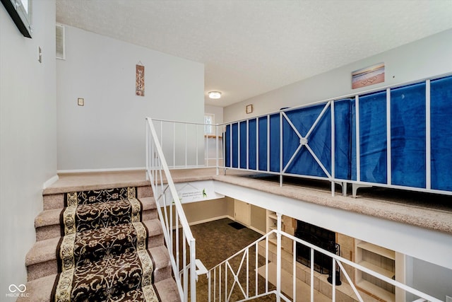 4020 Eisenhower Dr, Indianapolis, IN 46254 - stairway featuring carpet and a textured ceiling