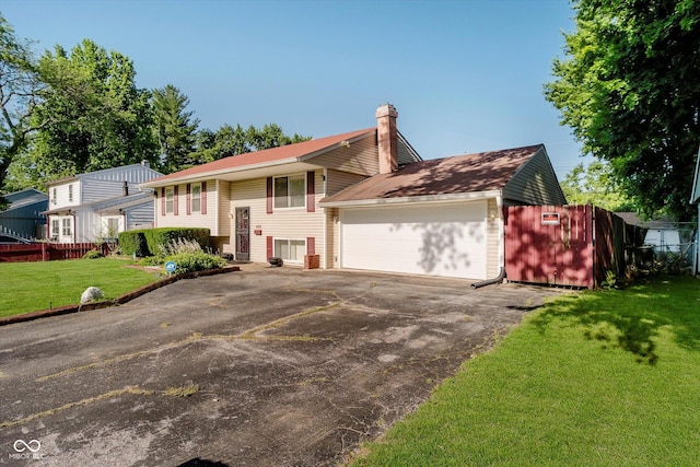 4020 Eisenhower Dr, Indianapolis, IN 46254 - raised ranch featuring a chimney, asphalt driveway, and a garage