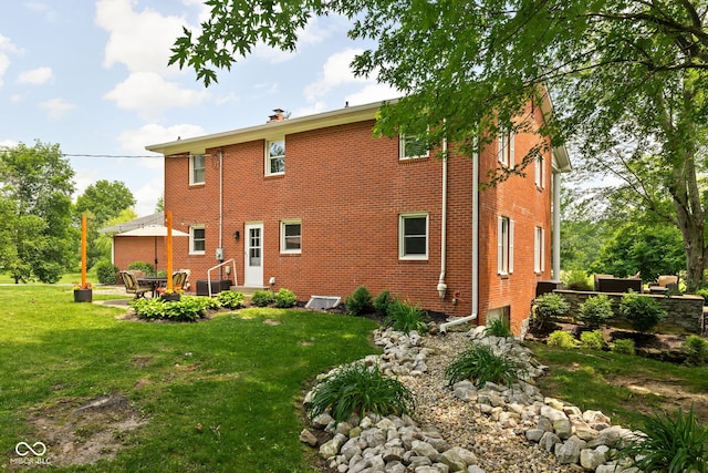 10198 N State Road 75, North Salem, IN 46165 - rear view of property featuring a lawn, a patio, brick siding, entry steps, and a chimney