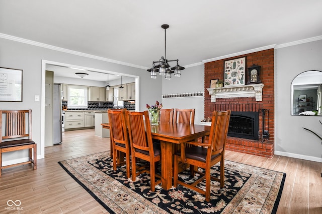 10198 N State Road 75, North Salem, IN 46165 - dining room featuring light wood-style flooring, crown molding, a fireplace, and a chandelier