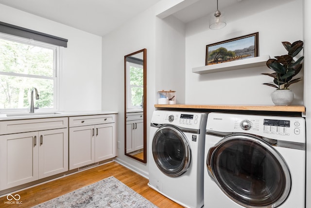 10198 N State Road 75, North Salem, IN 46165 - washroom featuring separate washer and dryer, light wood-style flooring, and cabinet space