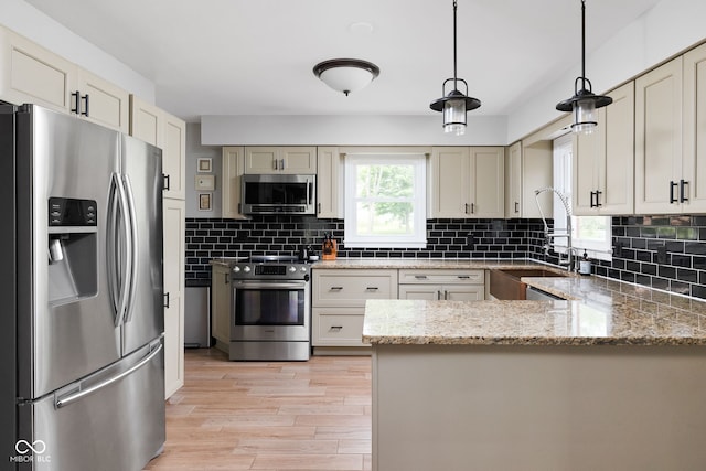 10198 N State Road 75, North Salem, IN 46165 - kitchen with appliances with stainless steel finishes, a peninsula, light wood-type flooring, and tasteful backsplash