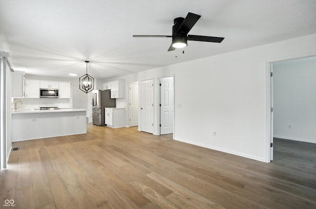 13264 Penneagle Dr, Carmel, IN 46033 - unfurnished living room with light wood-style floors, a chandelier, and ceiling fan