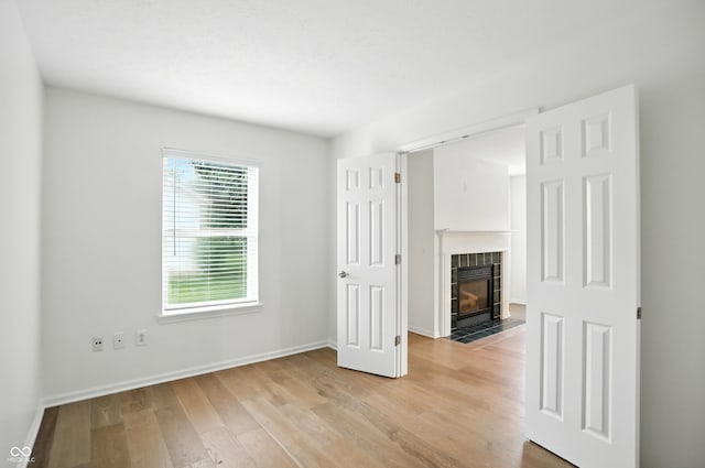 13264 Penneagle Dr, Carmel, IN 46033 - unfurnished living room with light wood-style floors and a tiled fireplace