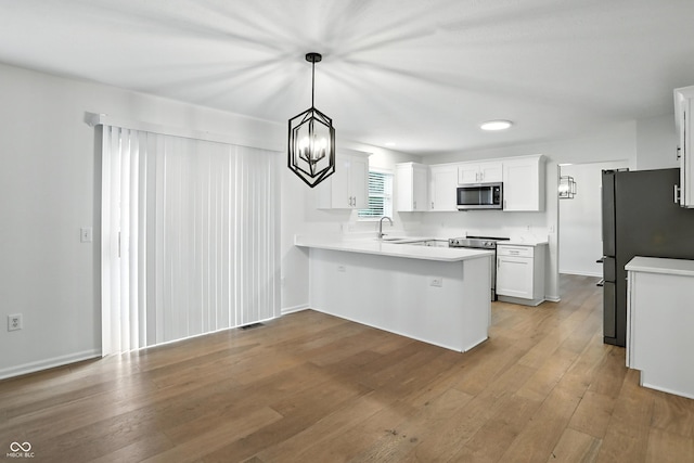 13264 Penneagle Dr, Carmel, IN 46033 - kitchen with appliances with stainless steel finishes, a peninsula, light wood finished floors, white cabinetry, and light countertops