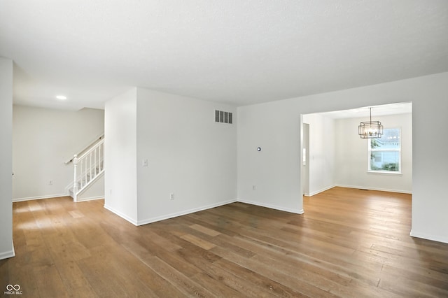13264 Penneagle Dr, Carmel, IN 46033 - unfurnished room featuring wood-type flooring, a chandelier, and stairway