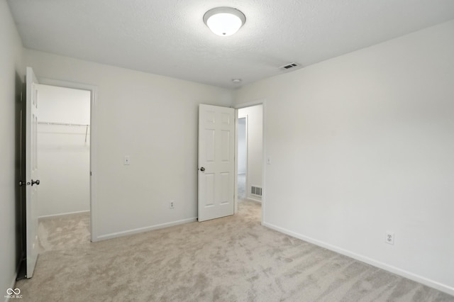 13264 Penneagle Dr, Carmel, IN 46033 - unfurnished bedroom featuring a spacious closet, carpet floors, a textured ceiling, and a closet