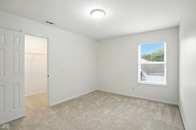 13264 Penneagle Dr, Carmel, IN 46033 - unfurnished bedroom with a spacious closet, light colored carpet, a closet, and a textured ceiling