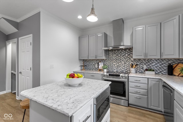 1141 W 35th St, Indianapolis, IN 46208 - kitchen featuring wall chimney exhaust hood, stainless steel appliances, gray cabinetry, light wood-type flooring, and ornamental molding