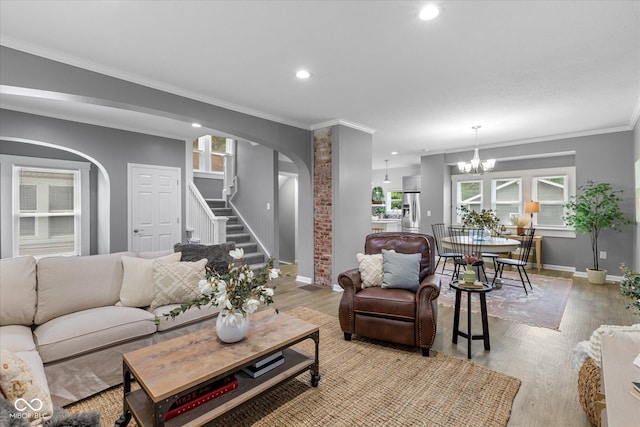 1141 W 35th St, Indianapolis, IN 46208 - living room with arched walkways, stairway, light wood-style flooring, a chandelier, and recessed lighting