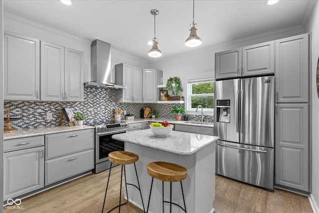 1141 W 35th St, Indianapolis, IN 46208 - kitchen featuring stainless steel appliances, wall chimney range hood, light wood finished floors, tasteful backsplash, and ornamental molding