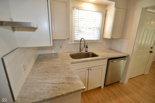 4930 Primrose Ave N, Indianapolis, IN 46205 - kitchen featuring stainless steel dishwasher, light wood-type flooring, backsplash, and light stone counters