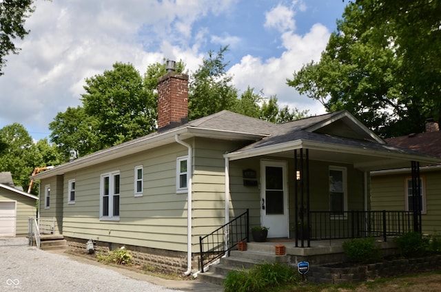 4930 Primrose Ave N, Indianapolis, IN 46205 - view of front facade featuring covered porch, a chimney, and a shingled roof