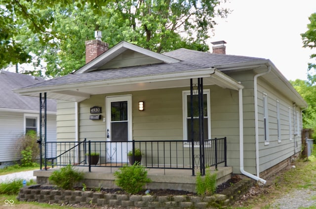 4930 Primrose Ave N, Indianapolis, IN 46205 - bungalow-style house featuring a chimney, covered porch, and roof with shingles