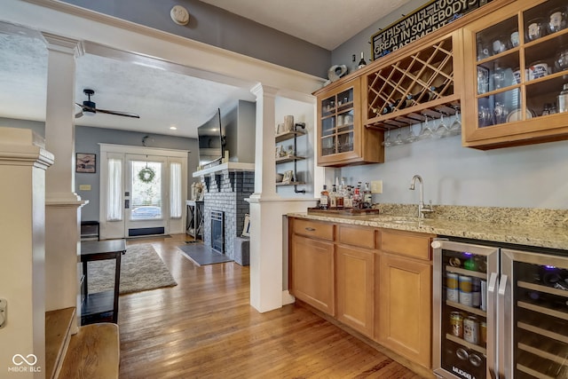 2332 Central Ave, Indianapolis, IN 46205 - indoor wet bar with ornate columns, a ceiling fan, light wood-style flooring, and wine cooler