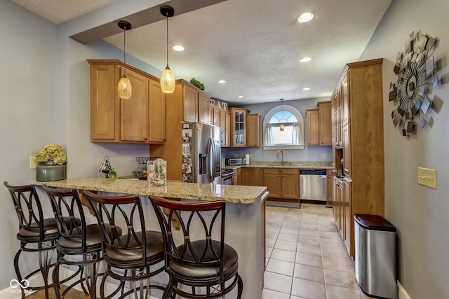 2332 Central Ave, Indianapolis, IN 46205 - kitchen with appliances with stainless steel finishes, a peninsula, recessed lighting, light stone countertops, and a kitchen bar
