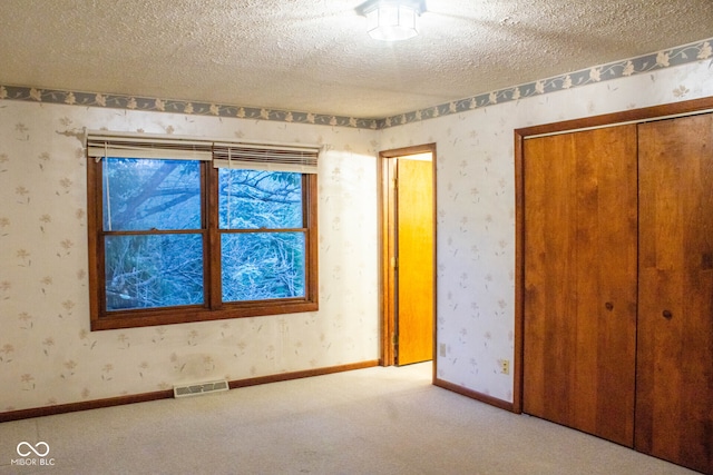 3401 N 75 W, Cayuga, IN 47928 - unfurnished bedroom featuring a textured ceiling, wallpapered walls, carpet flooring, and a closet